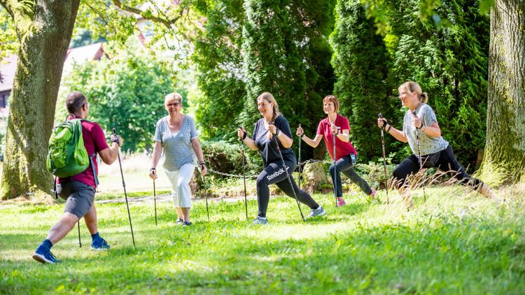 Patientengruppe wärmt sich fürs Nordic Walking auf
