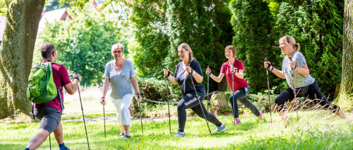 Patientengruppe wärmt sich fürs Nordic Walking auf