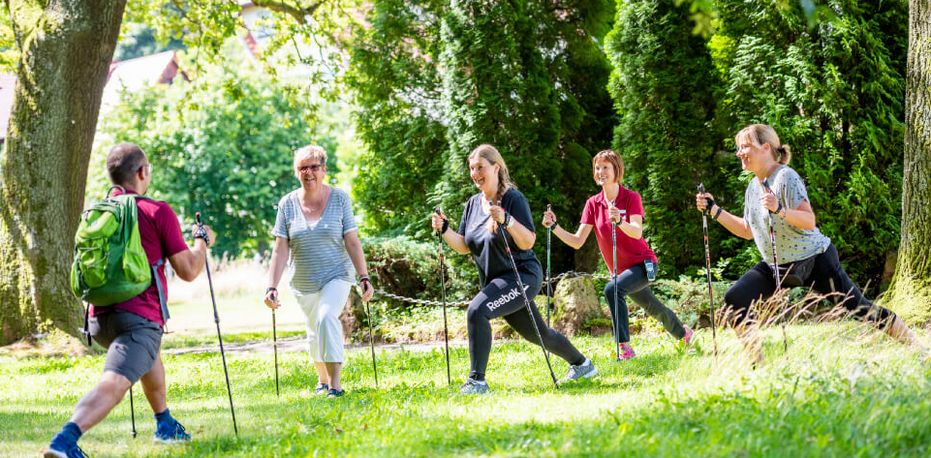 Patientengruppe wärmt sich fürs Nordic Walking auf