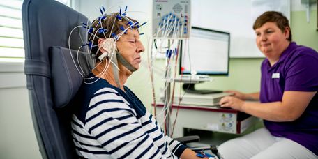 Fachkraft misst Gehirnströme einer Patientin