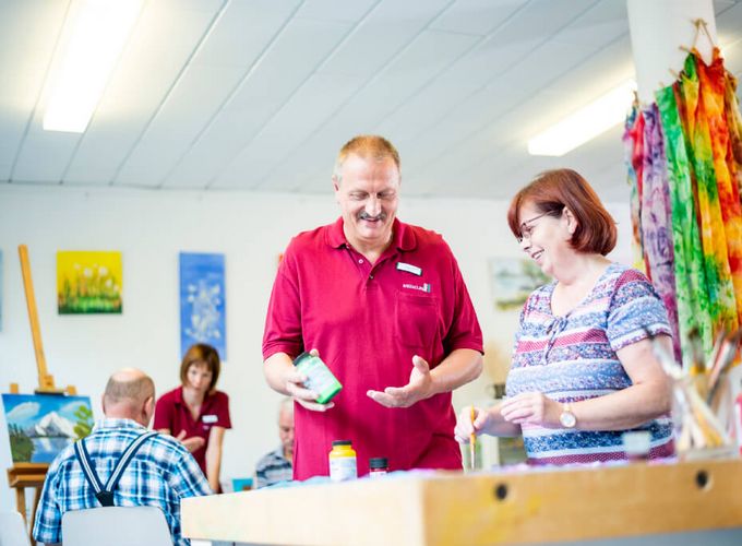 Therapeut und Patientin wählen Farben für ein Bild in der Kunsttherapie aus