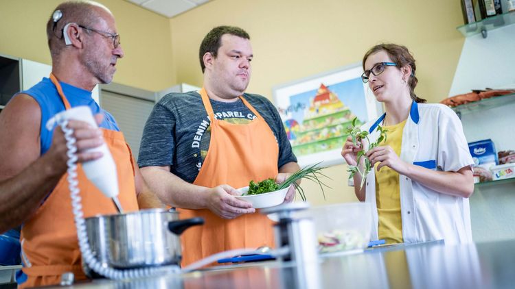 Patienten bereiten in der Lehrküche unter Anleitung einer Therapeutin gesundes Essen zu