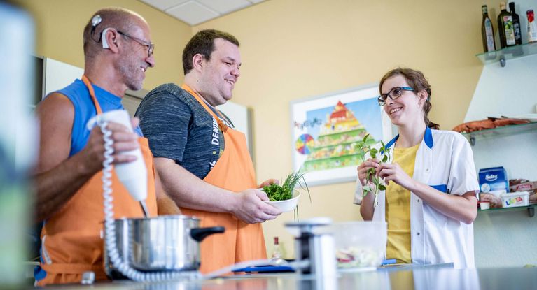 Patienten bereiten unter Anleitung einer Therapeutin gesundes Essen zu