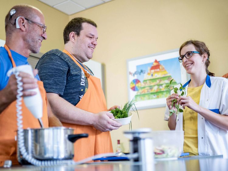 Patienten bereiten unter Anleitung einer Therapeutin gesundes Essen zu