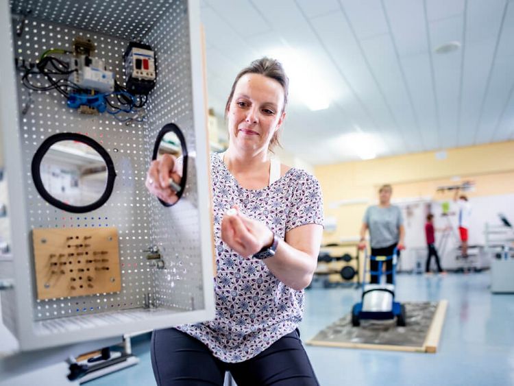 Patientin trainiert Fingerfertigkeit in der medizinisch-beruflich orientierten Rehabilitation