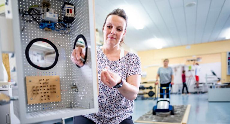 Patientin trainiert Fingerfertigkeit in der medizinisch-beruflich orientierten Rehabilitation